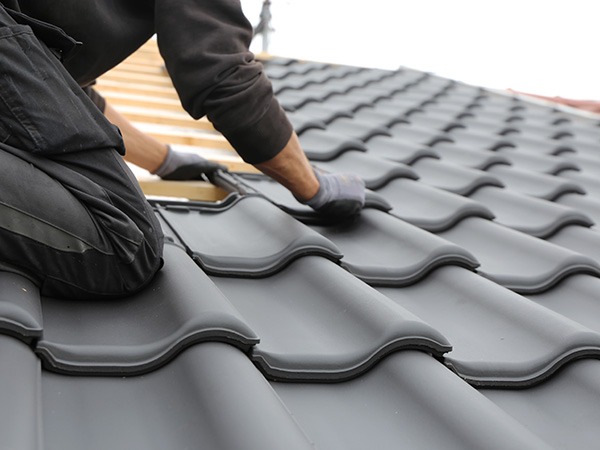 Expert roofer installing tiles with precision